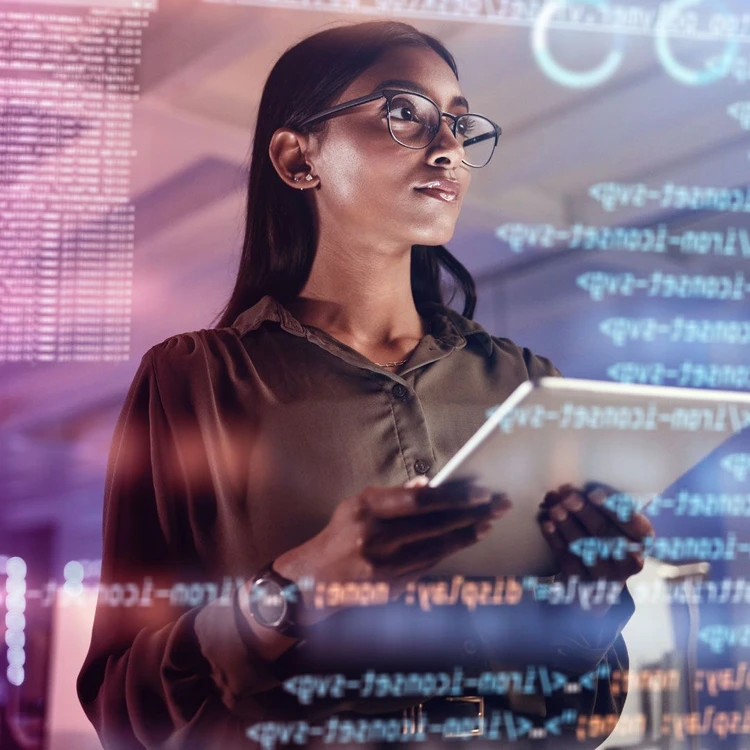 A young leader works on tablets and checks strings of programming code.